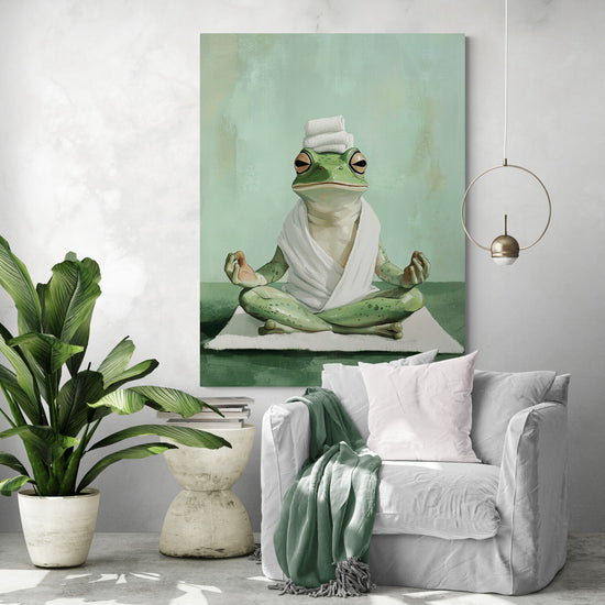 Une peinture humoristique représentant une grenouille assise en position de méditation, enveloppée dans une serviette blanche avec une pile de serviettes sur la tête. Elle est accrochée dans un salon au style bohème avec un fauteuil blanc, une couverture verte et une grande plante d’intérieur.