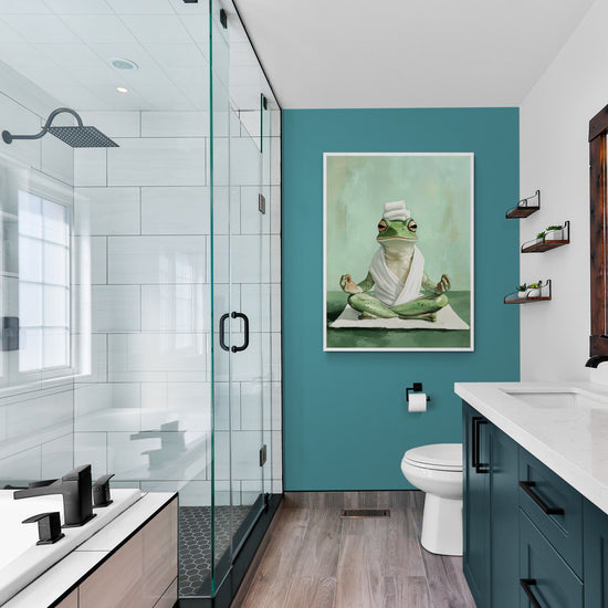 Le tableau de la grenouille en pleine méditation est intégré dans une salle de bain moderne avec des meubles bleu canard, une douche vitrée et un design minimaliste. L’œuvre apporte une touche ludique et apaisante à l’espace.