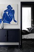 commode bleu nuit, vase décoratif, entré de chambre parentale, mur blanc, poster femme couleur bleu foncé.